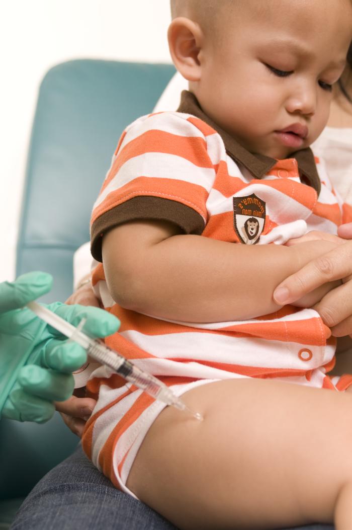 Young boy receiving vaccination in thigh muscle. Photo from Public Helath Image Library #13519